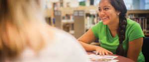 A student in a library reviewing brochures.