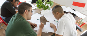 A group of students working on schoolwork around a table.