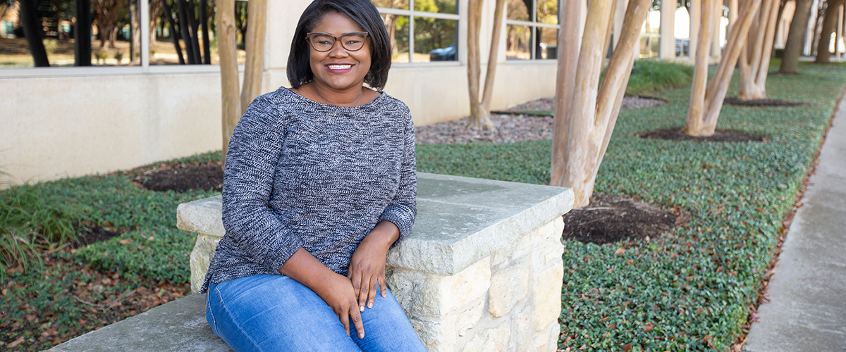 An image of LaKya Lewis smiling in from of the Trellis headquarters.