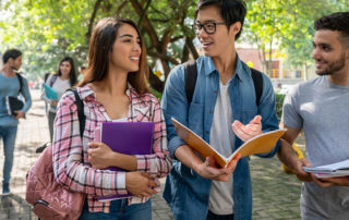 A group of students walking to class and looking over schoolwork.