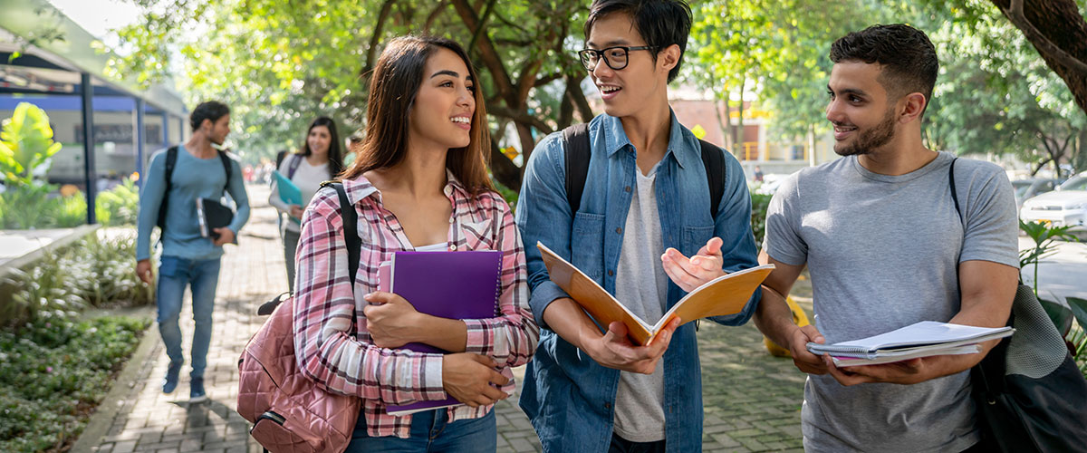 A group of students walking to class and looking over schoolwork.