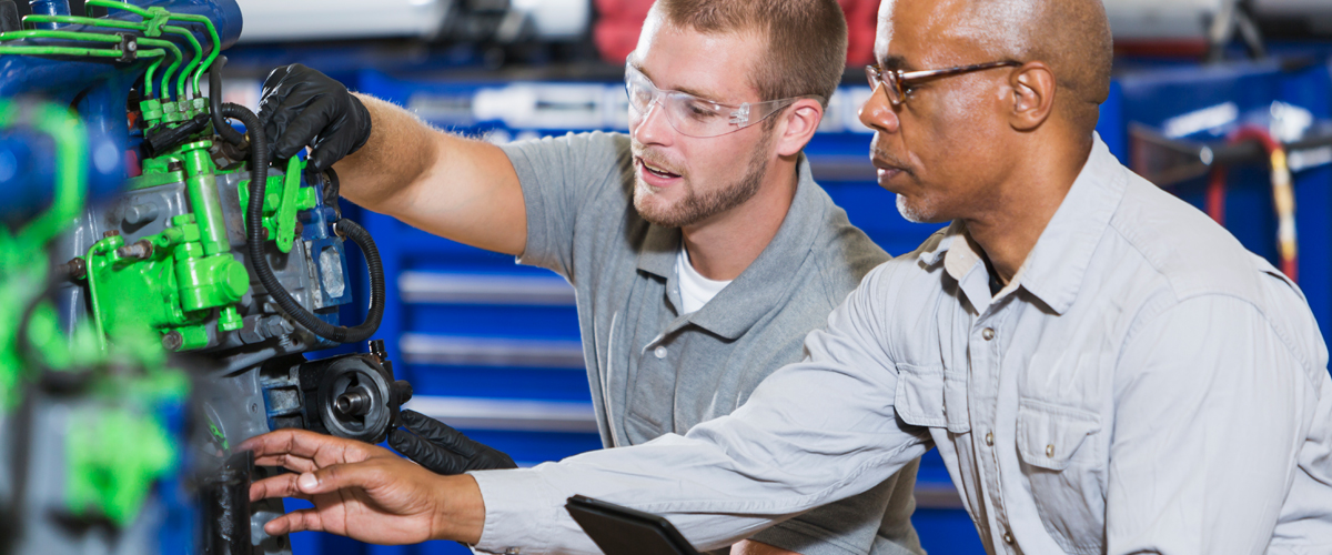 An image of two men working on mechanical equipment.