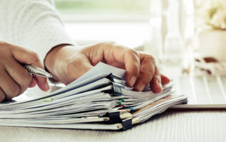 An image of an employee reviewing a stack of files.