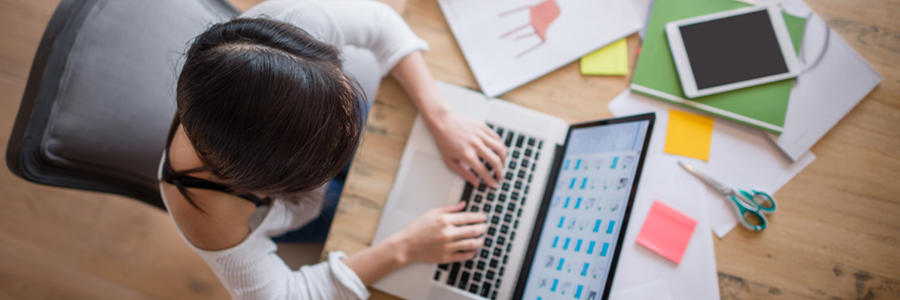 An image of a student working on laptop at her desk.