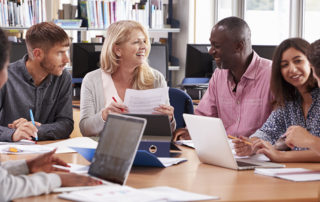 An image of a group of students working together around a table in a library.