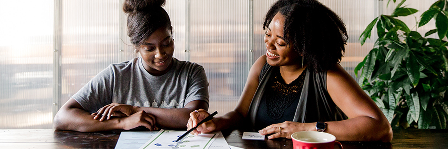 An image of two women looking over documentation.